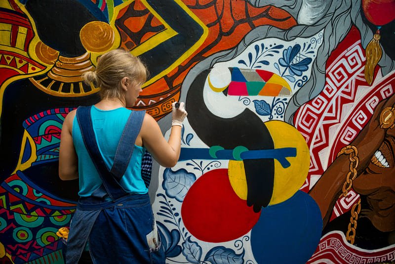 artista urbana pintando mural