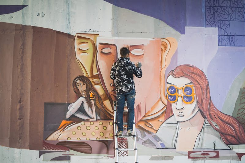 artista urbano pintando um mural 
