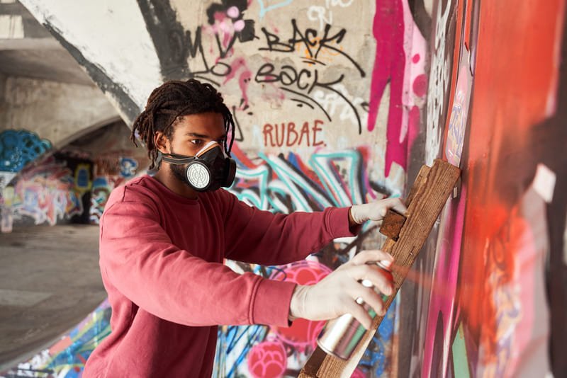 artista urbano grafitando uma parede