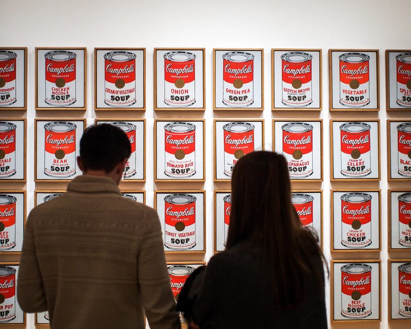 Homem e mulher observando obra Lata de Sopa Campbell no Museu MOMA
