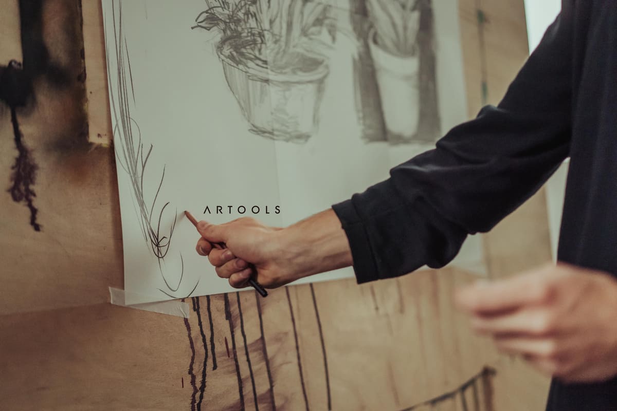 Artista desenhando no papel com material de arte da Artools